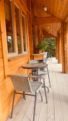 a porch of a cabin with a table and chairs at APPLE Cabin - Little Log Cabin in Wales in Newtown