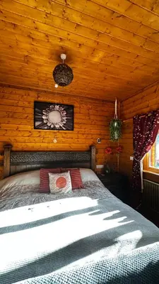 a bedroom with a bed in a wooden cabin at APPLE Cabin - Little Log Cabin in Wales in Newtown