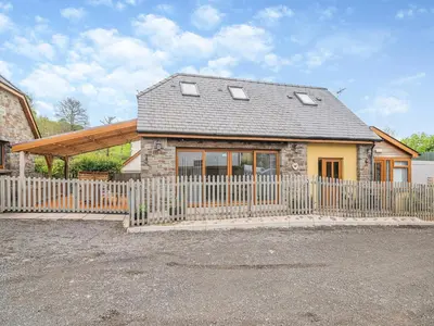 a house with a fence in front of it at The Old Nursery in Sennybridge