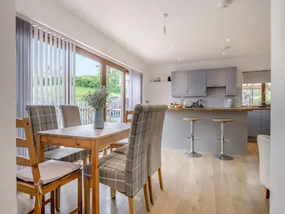 a kitchen and dining room with a wooden table and chairs at The Old Nursery in Sennybridge