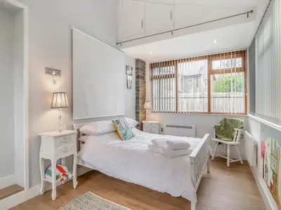 a bedroom with a white bed and a window at The Old Nursery in Sennybridge