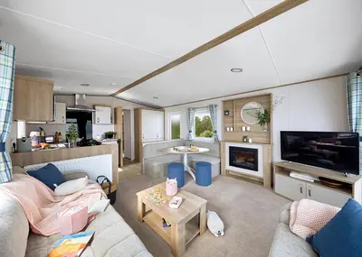 a living room with a couch and a tv at Ocean Heights Holiday Park in New Quay