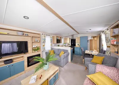 a caravan living room with a couch and a tv at Ocean Heights Holiday Park in New Quay