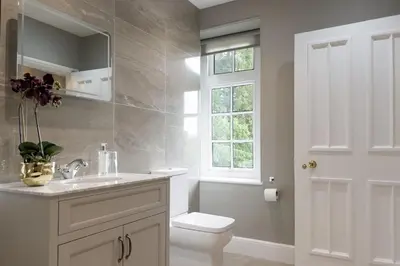 a bathroom with a toilet and a sink and a window at Marrington Hall in Chirbury