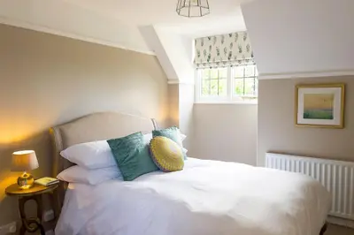a bedroom with a white bed with pillows and a window at Marrington Hall in Chirbury