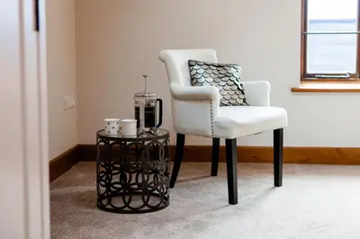 a white chair and a table in a room at Camlad Barn in Chirbury