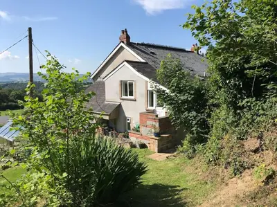 a house on the side of a hill at Ravens Rest in Llanwrda