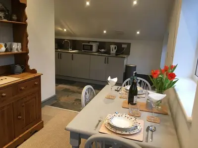 a kitchen with a table with a plate of food at Ravens Rest in Llanwrda