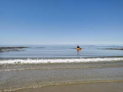 a person in a kayak in the water at the beach at Snowdonia Sunbeach Holiday Sea and Mountain view in Llwyngwril