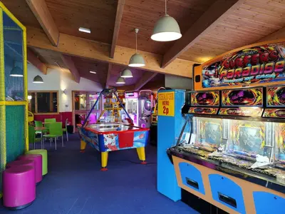 two arcade games in a room with tables and chairs at Snowdonia Sunbeach Holiday Sea and Mountain view in Llwyngwril