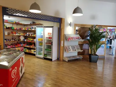 a store with a coca cola refrigerator in a room at Snowdonia Sunbeach Holiday Sea and Mountain view in Llwyngwril
