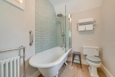 a bathroom with a tub and a toilet and a sink at 4 Bed in Brithdir oc-wag722 in Cross Foxes