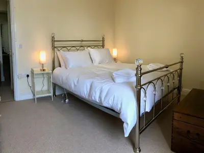 a bedroom with a large bed with white sheets and pillows at Stunning Aberystwyth South Beach Apartment in Aberystwyth