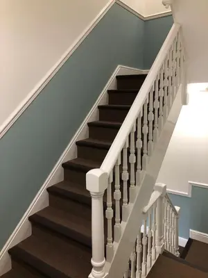 a stairway with white railings and brown stairs at Stunning Aberystwyth South Beach Apartment in Aberystwyth