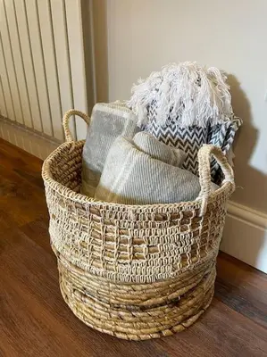 a basket filled with towels on a wooden floor at Georgian 3 bed house in historic town centre in Shrewsbury