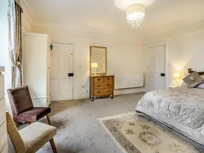 a bedroom with a bed and a chair and a mirror at Brynog Mansion Apartment in Cilcennin