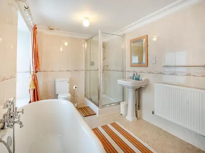 a bathroom with a tub and a sink and a shower at Brynog Mansion Apartment in Cilcennin