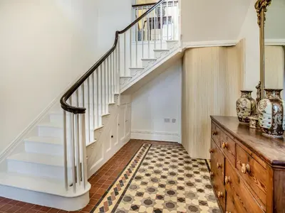 a staircase in a home with a checkered floor at Brynog Mansion Apartment in Cilcennin