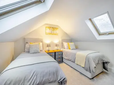 two beds in a attic bedroom with a window at Yr Hen Beudy in Tregaron