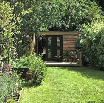 a small cabin in a garden with a lawn at Dove Cottage in Newbridge on Wye