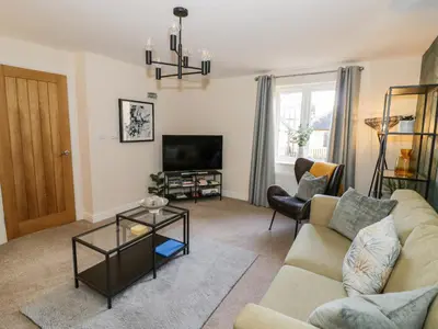 a living room with a couch and a tv at The Stokesay in Ludlow