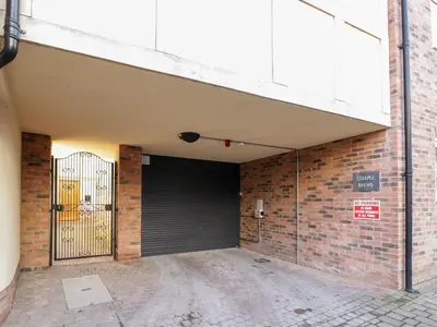 an empty parking lot with a garage door and a brick wall at The Stokesay in Ludlow