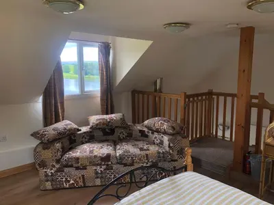 a living room with a couch and a window at Lake view Romantic retreat in Aberystwyth