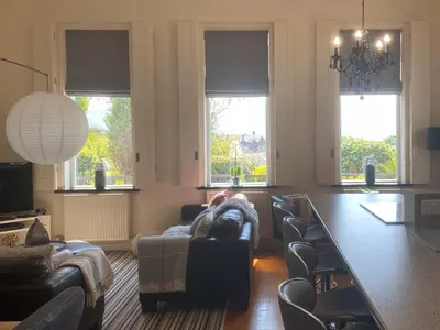 a living room with a couch and chairs and windows at Tre Mynach Barmouth in Barmouth