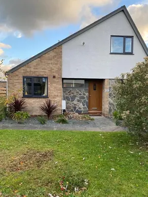 a brick house with a brown door in a yard at Holiday home, Tywyn, great location in Tywyn