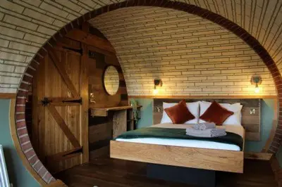 a bedroom with a bed in a brick wall at Hedgehogs View in Rhayader
