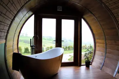 a bath tub in a room with a large window at Hedgehogs View in Rhayader