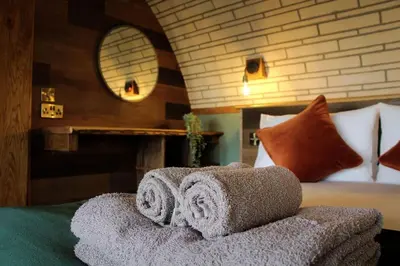 a bedroom with a bed with towels on it at Hedgehogs View in Rhayader