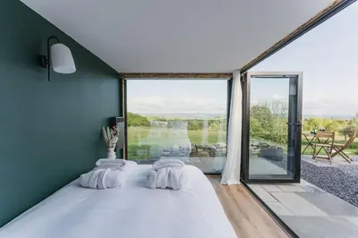 a bedroom with a bed and a large window at Dyffryn Ceri in Penuwch