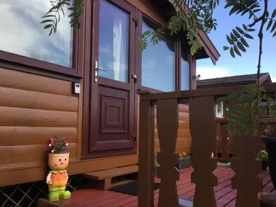 a front door of a house with a flower pot on a porch at Log cabin - free parking garden & pet friendly in Trawsfynydd
