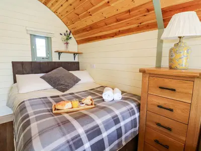 a bedroom with a bed with a tray of bread at Meadow View in Rhayader