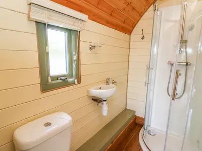 a bathroom with a toilet and a sink and a shower at Meadow View in Rhayader