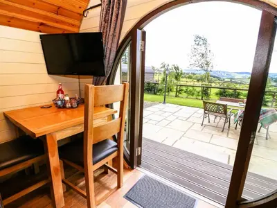 a screened in porch with a desk and a television at Meadow View in Rhayader