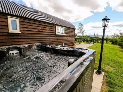 a swimming pool next to a house at Meadow View in Rhayader