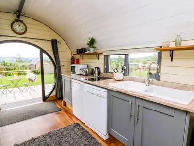 an eat in kitchen with a sink and a window at Mountain View Pod in Rhayader