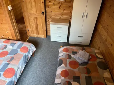 a bedroom with a bed and a dresser at Wye View Lodge, Hay View Lodges in Hereford