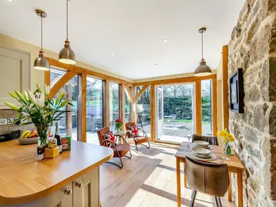 a kitchen with a stone wall and a table and chairs at The Mill in Llandegley