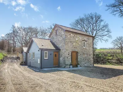 a small stone house with a dirt road at The Mill in Llandegley