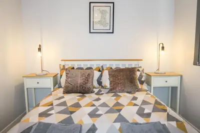 a bedroom with a bed with two lamps on both sides at Riverside Chalet in heart of Lampeter, West Wales in Lampeter