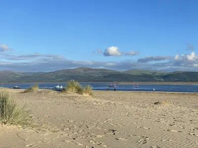 a sandy beach with boats in the water at Lovely seafront 2 bedroom Apartment 4 in Aberdyfi