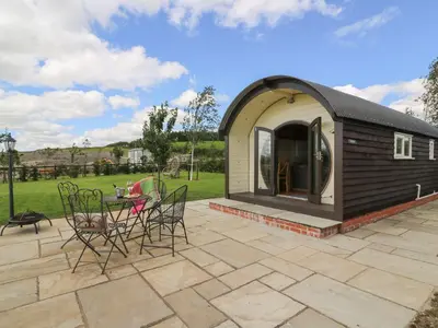 a small shed with chairs and a table on a patio at Valley View Pod in Rhayader