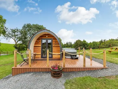 a small cabin with a deck and a tub at Beech Uk36260 in Llanfair Caereinion