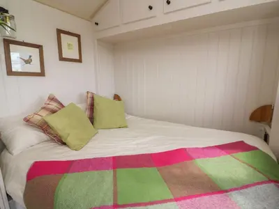 a bedroom with a bed with a colorful blanket on it at Shepherds View in Rhayader