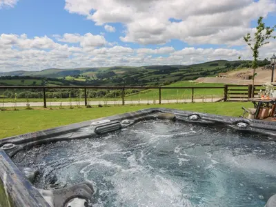 a hot tub with water in a field at Shepherds View in Rhayader