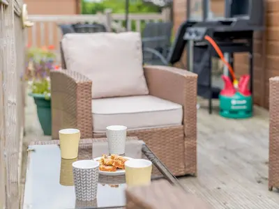 a table with a plate of food and a chair on a patio at Bryn Teg - Cottage in Maesmynis