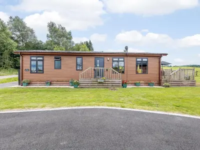a log cabin with a porch and a driveway at Bryn Teg - Cottage in Maesmynis